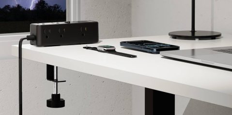 A desk with a smart watch and a laptop