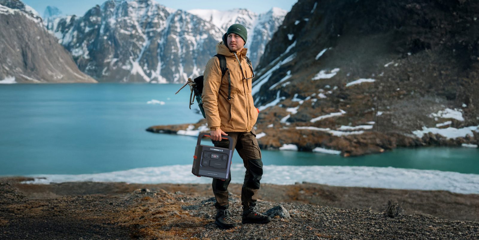 A man standing on a rocky shore with a radio