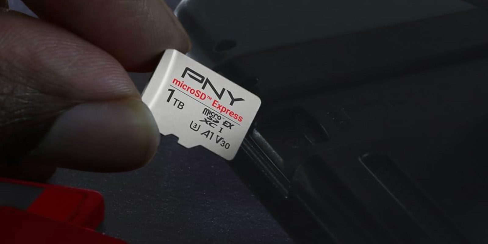 A hand holding a micro sd card