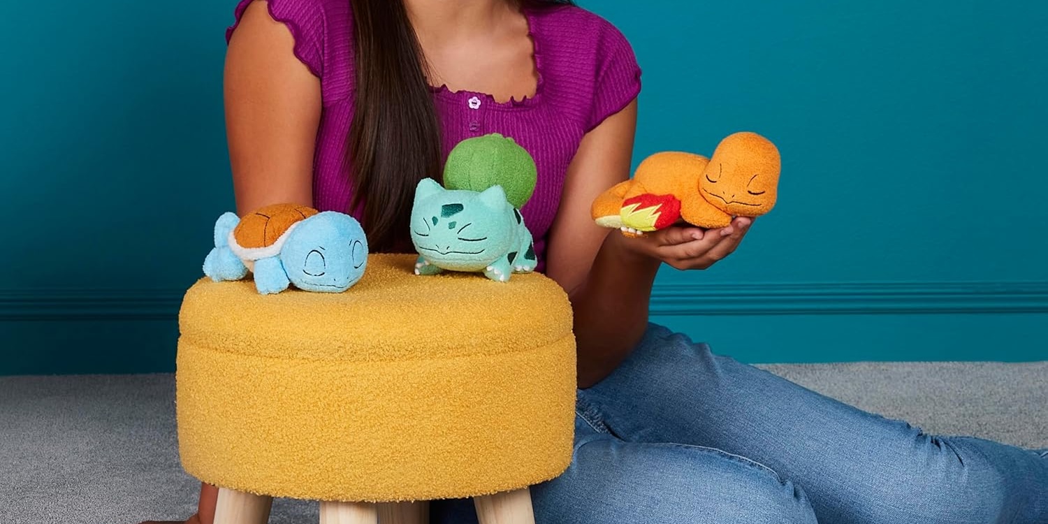 A woman sitting on a stool with stuffed animals