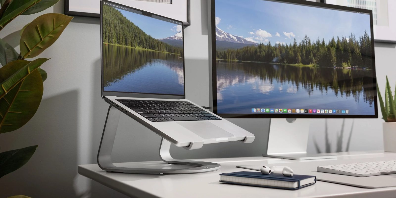 A laptop on a stand with two monitors