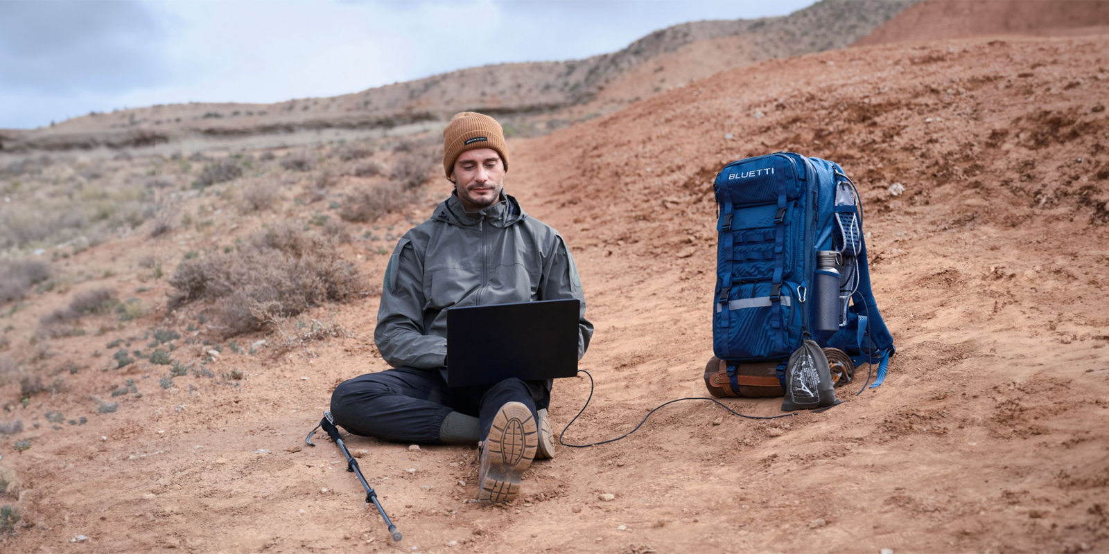 A man sitting on the ground with a laptop