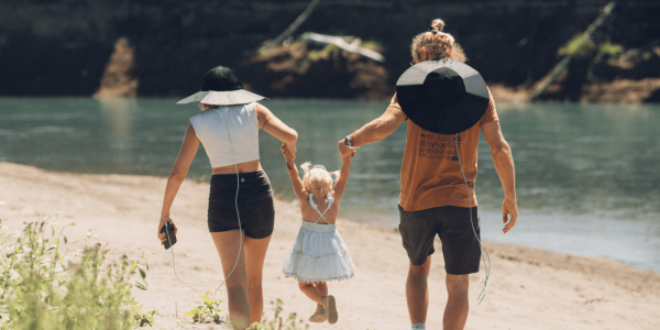 A group of people holding hands and walking on a beach