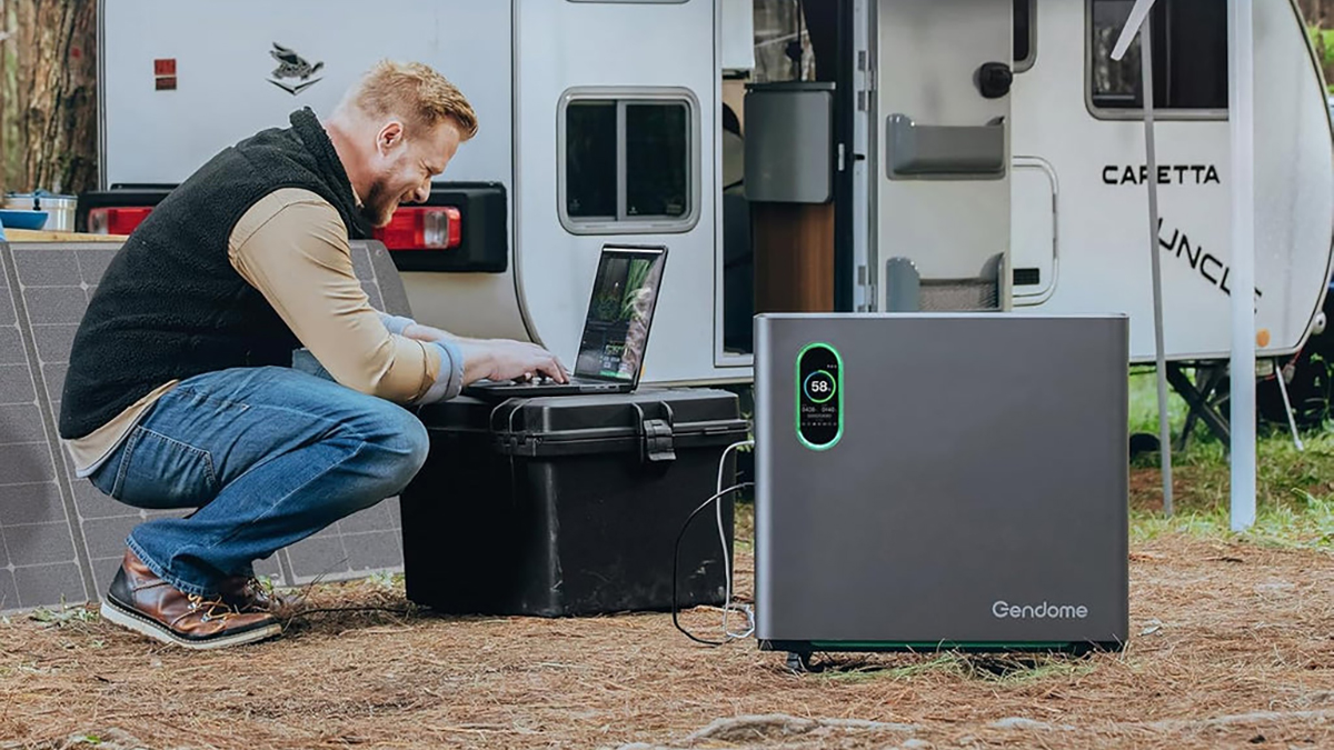A man kneeling next to a laptop