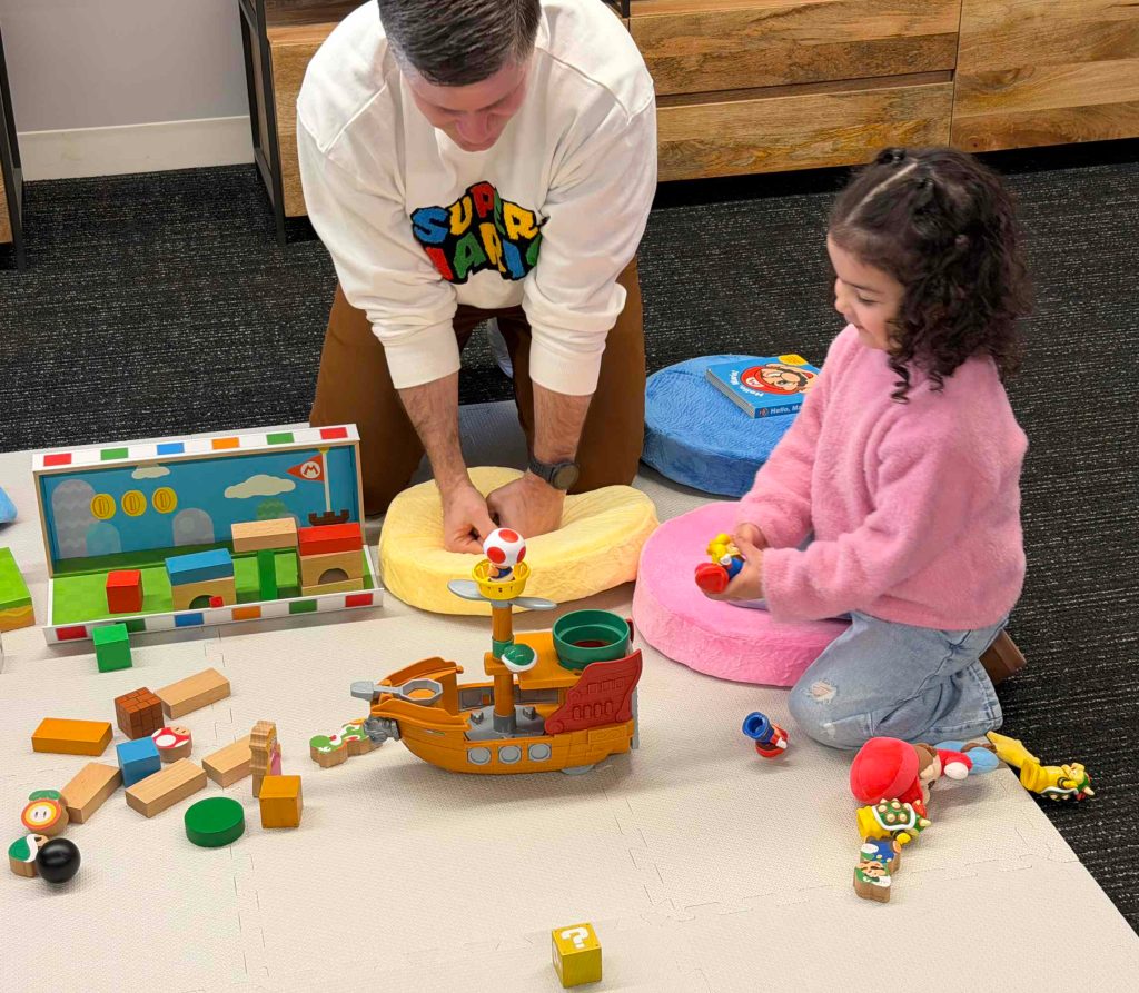 A man and a girl playing with toys