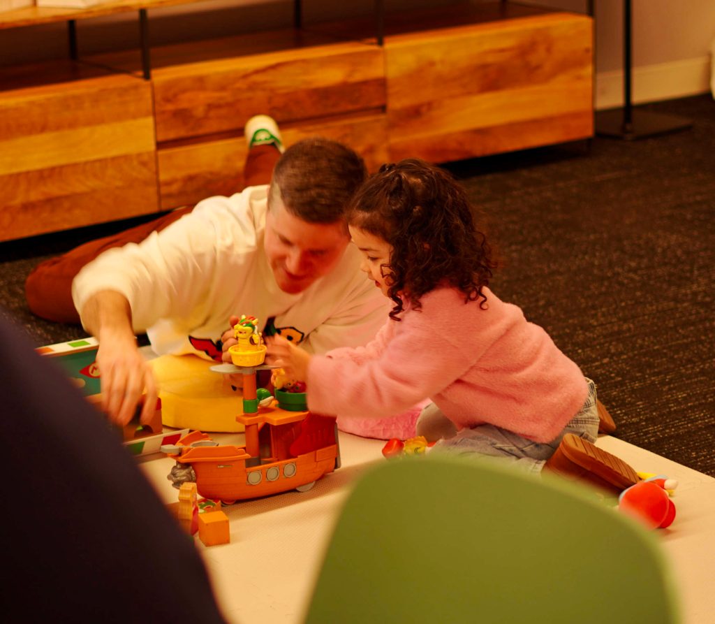 A man and a girl playing with toys