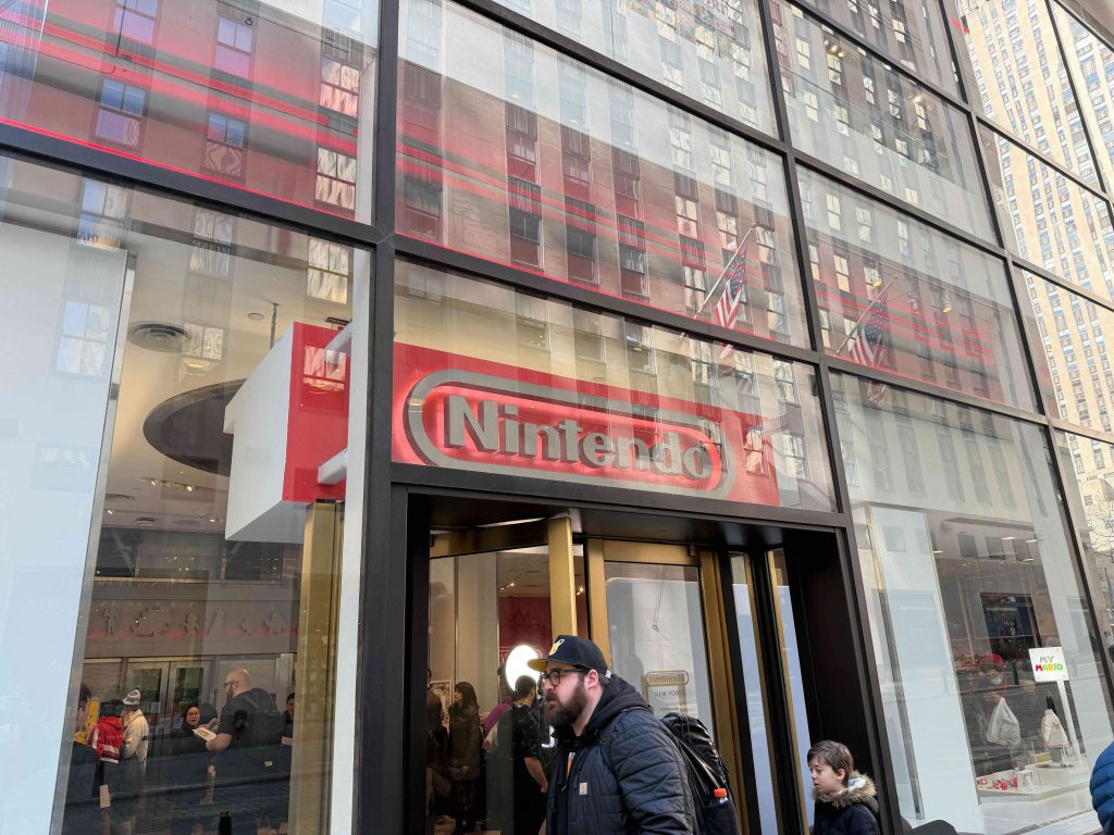A man walking in front of a building with a sign