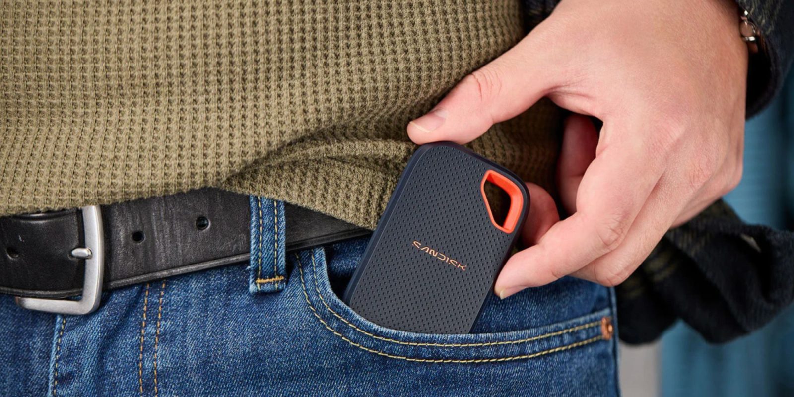 A person holding a device in their pocket