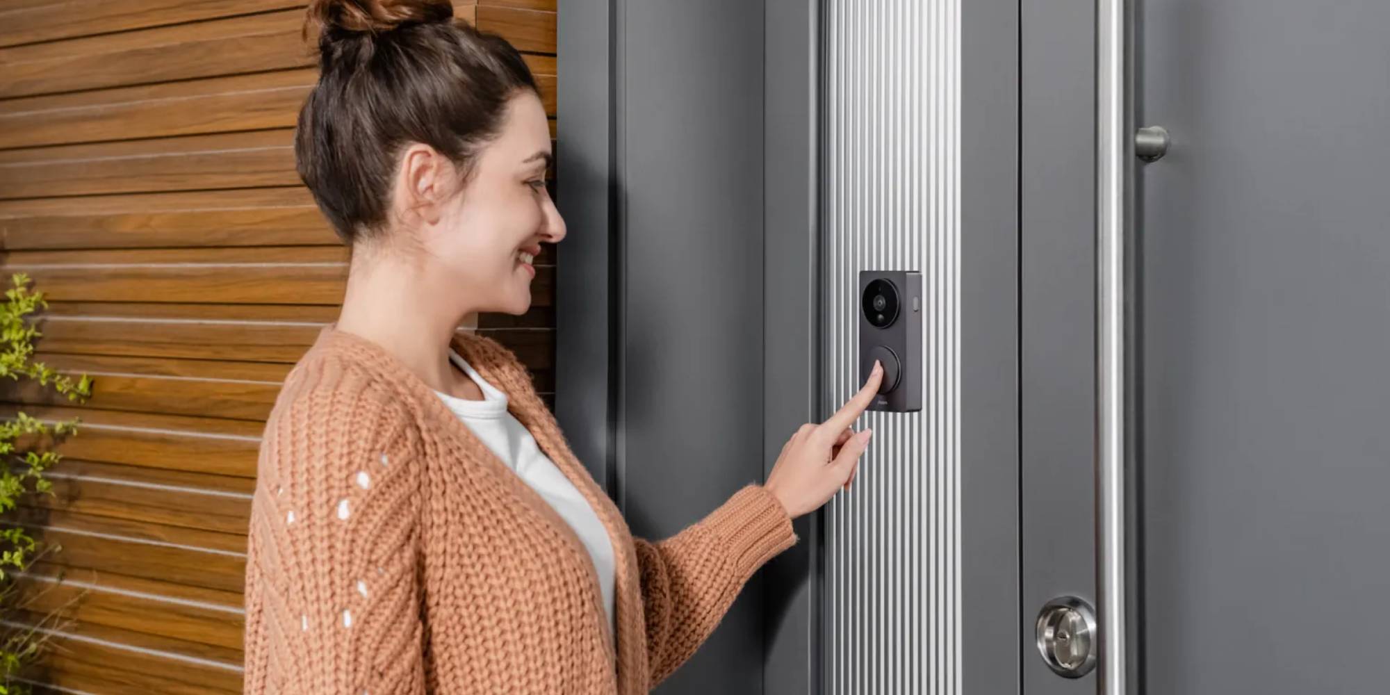 A woman pressing a video camera on a door