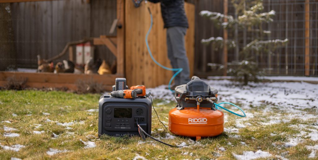 A couple of portable air compressors on grass