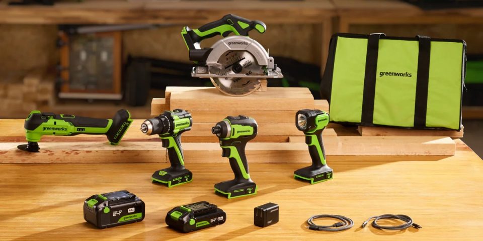 A group of green and black power tools on a wood table
