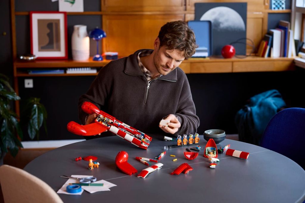 man building LEGO Tintin Moon Rocket