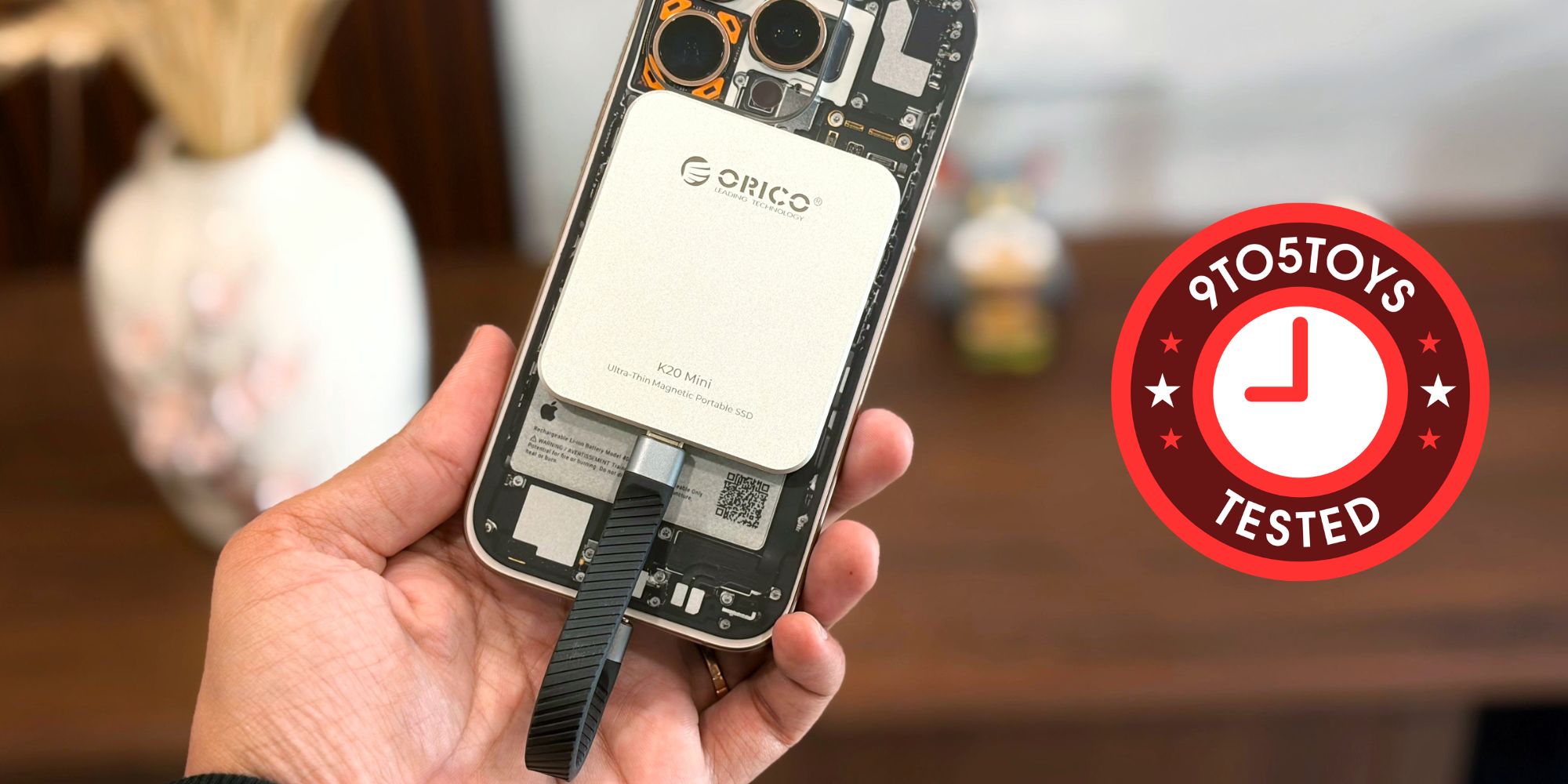 Image showing a person holding an iPhone with ORICO's K20 Mini SSD.