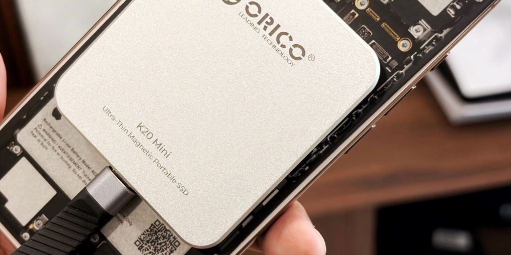 A hand holding a silver rectangular object