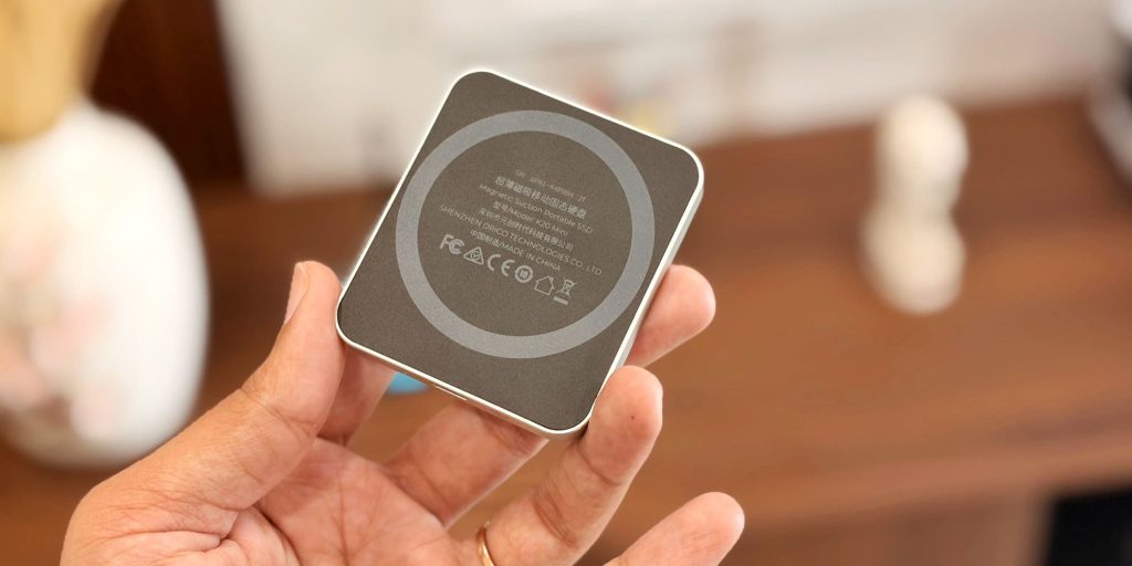 A hand holding a square device