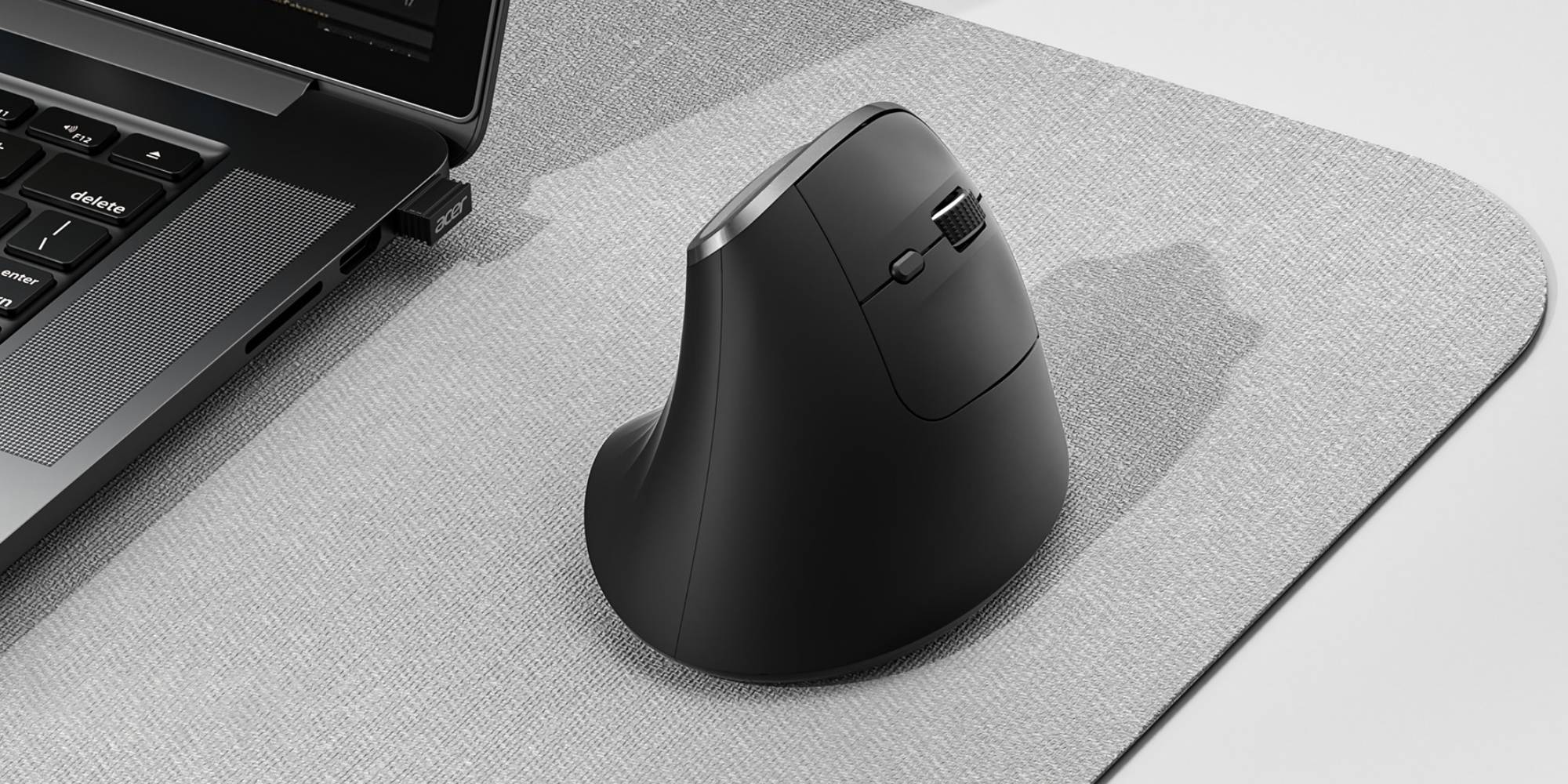 A black computer mouse on a gray surface