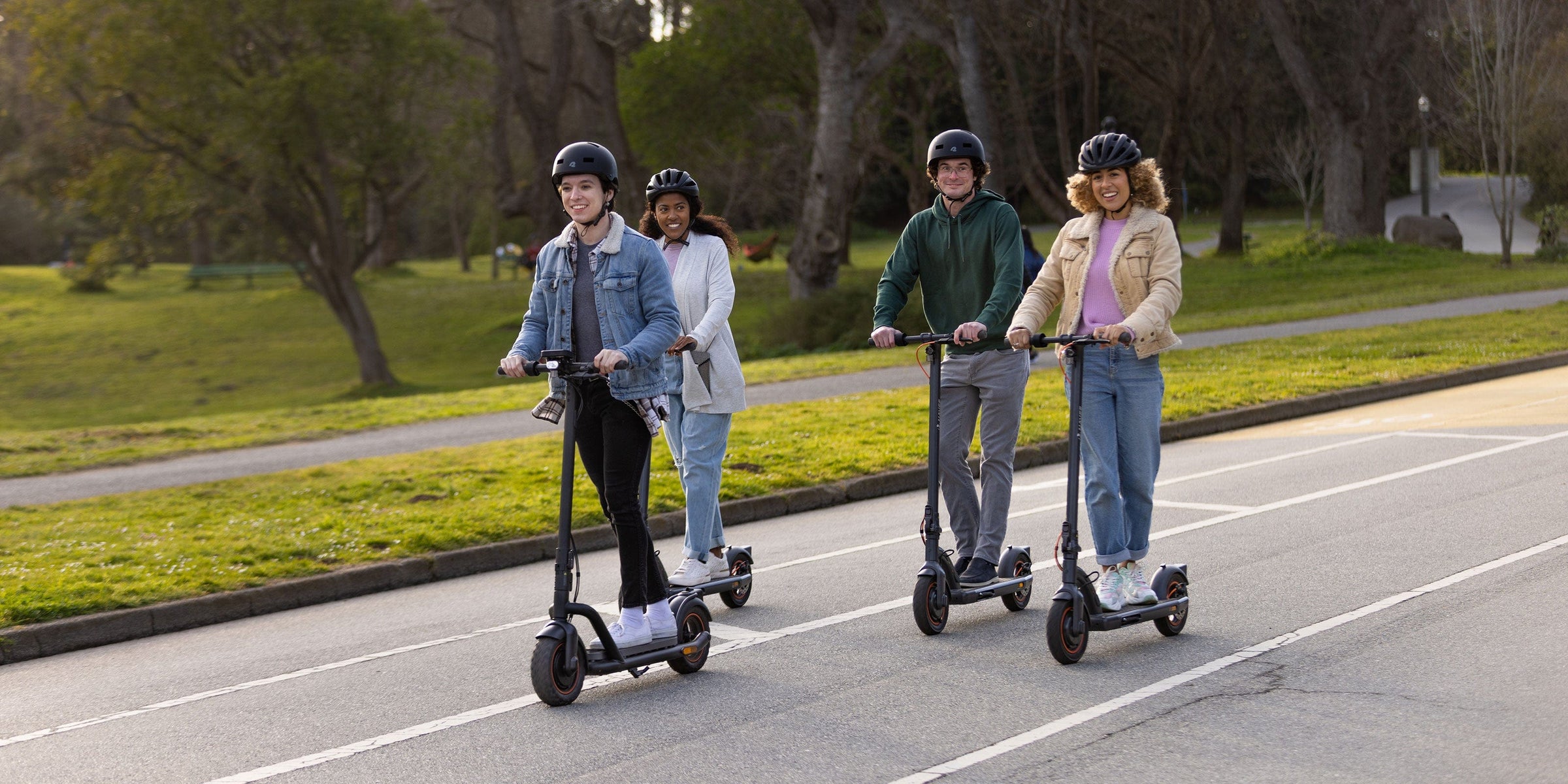 A group of people riding scooters on a road
