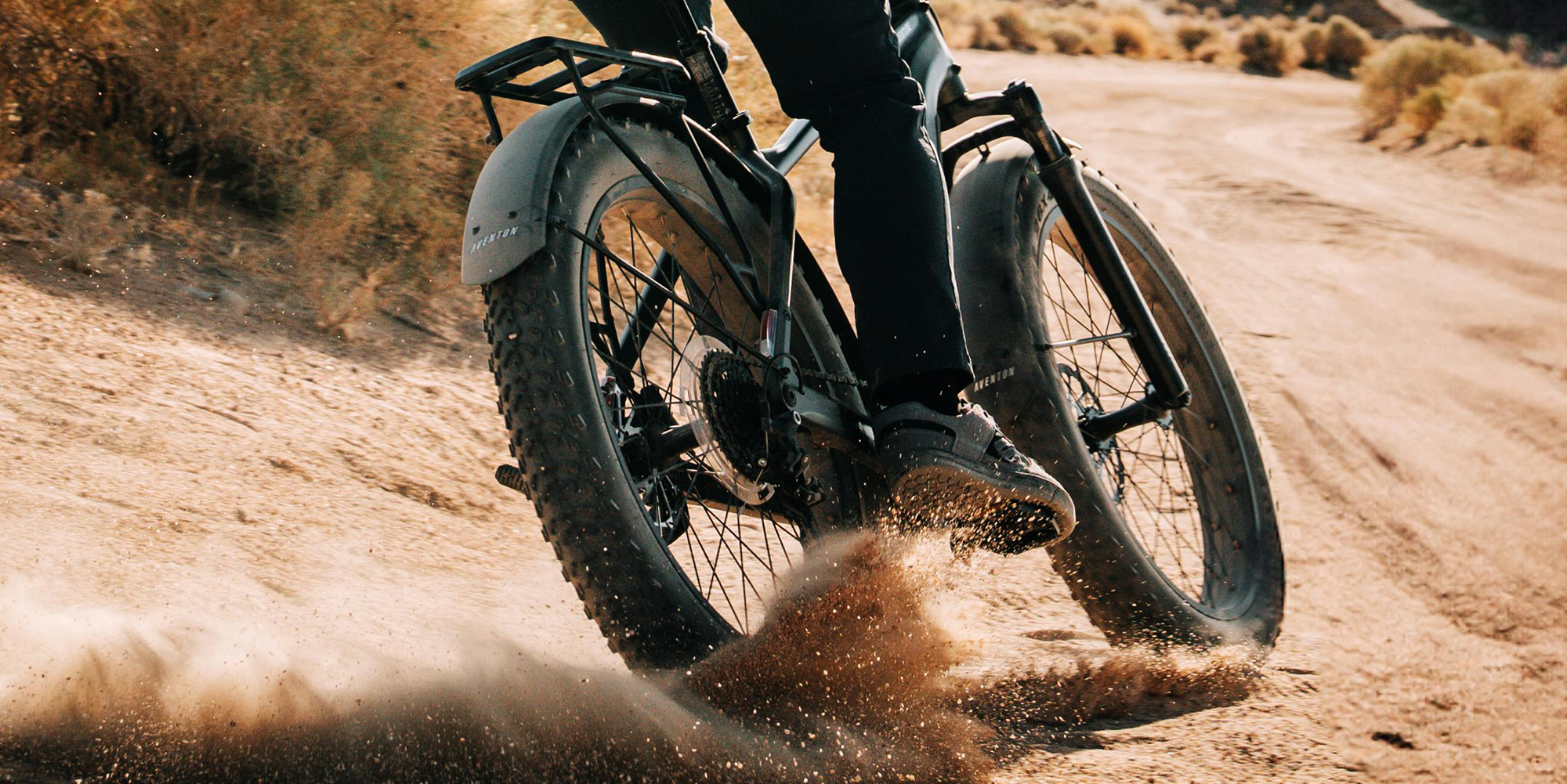 A person riding a bike in the sand