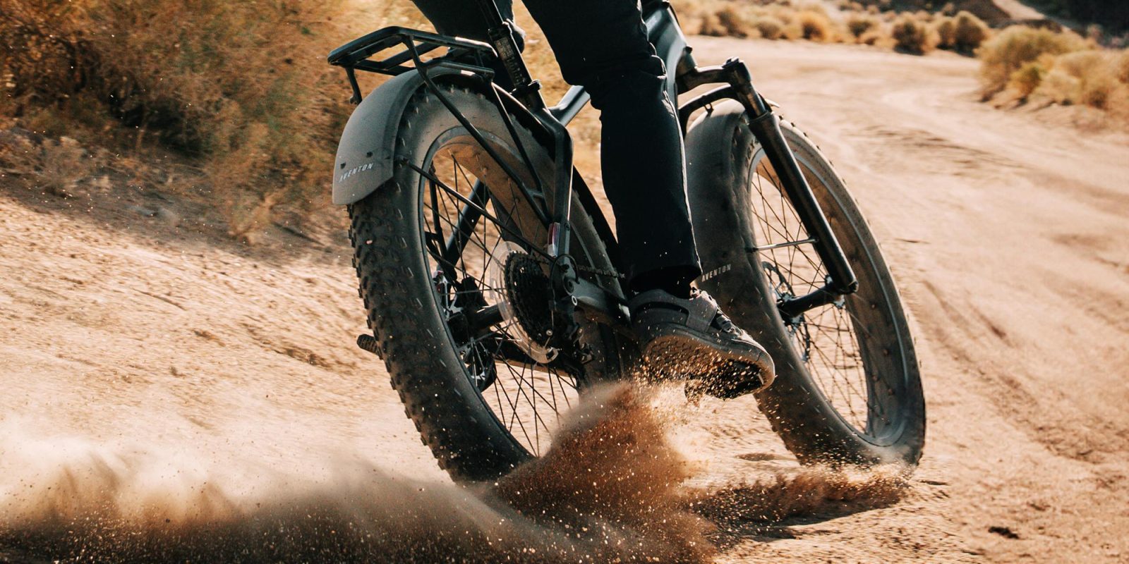 A person riding a bike in the sand