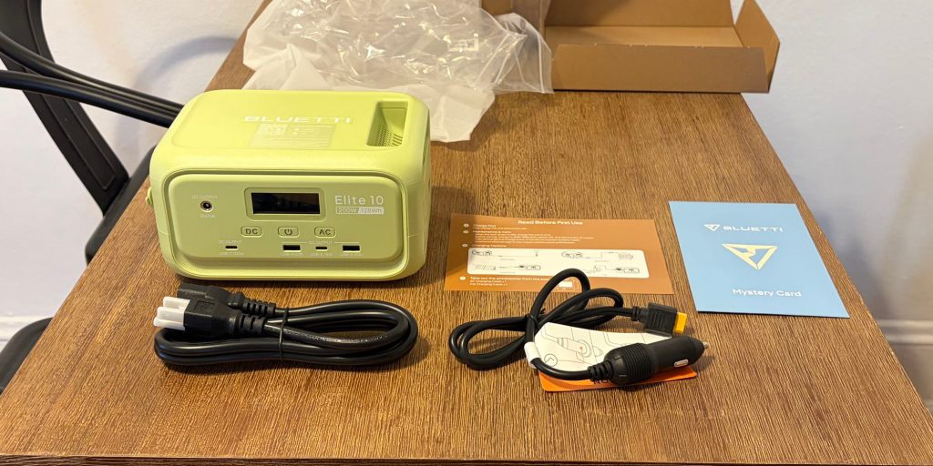 A green Elite 10 Mini power station with wires on a table