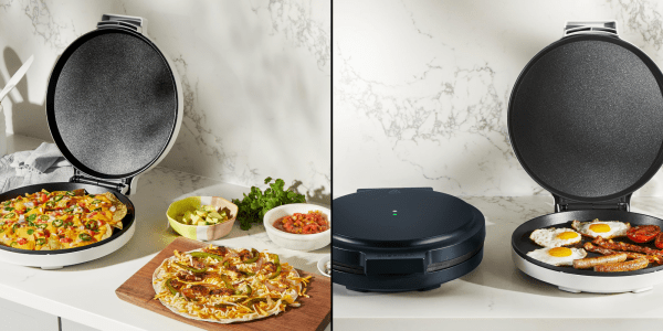 A pizza on a cutting board next to a machine