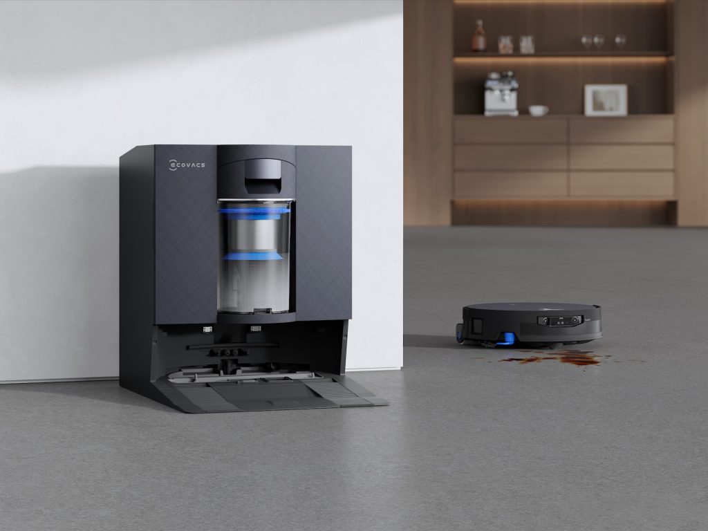 A robot vacuum cleaner next to a vacuum