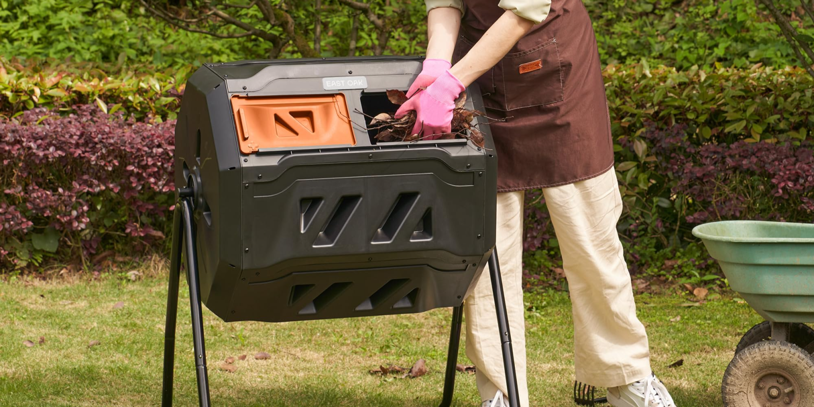 A person putting leaves in a trash can