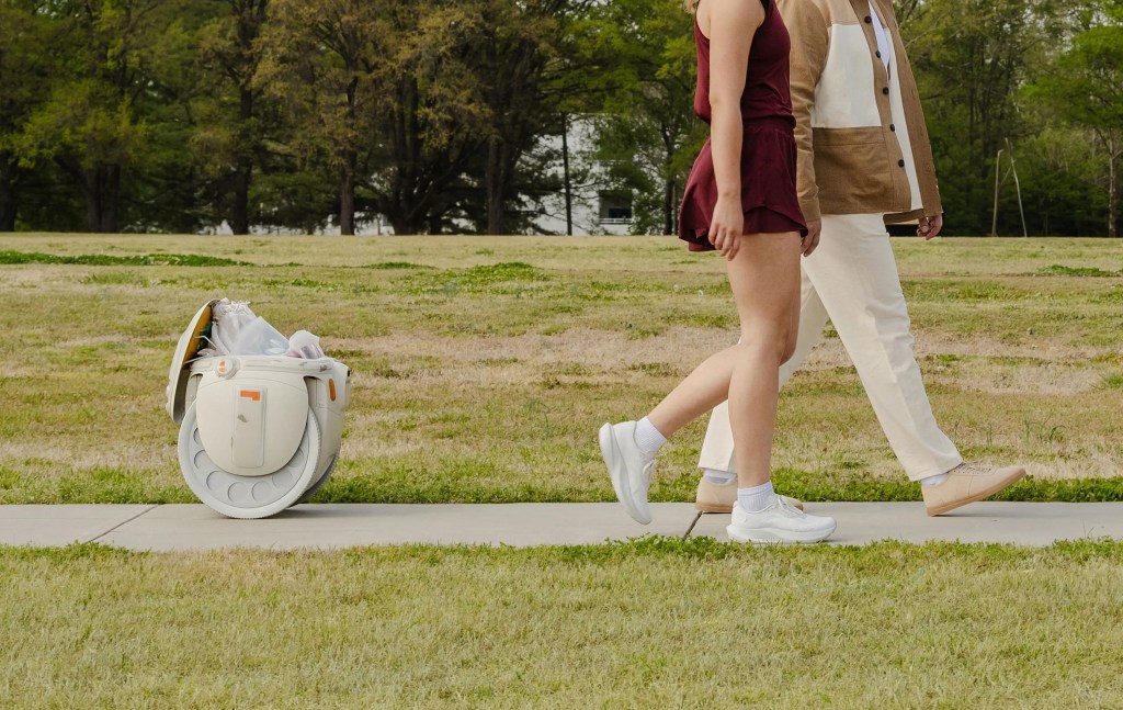 A man and woman walking on a sidewalk