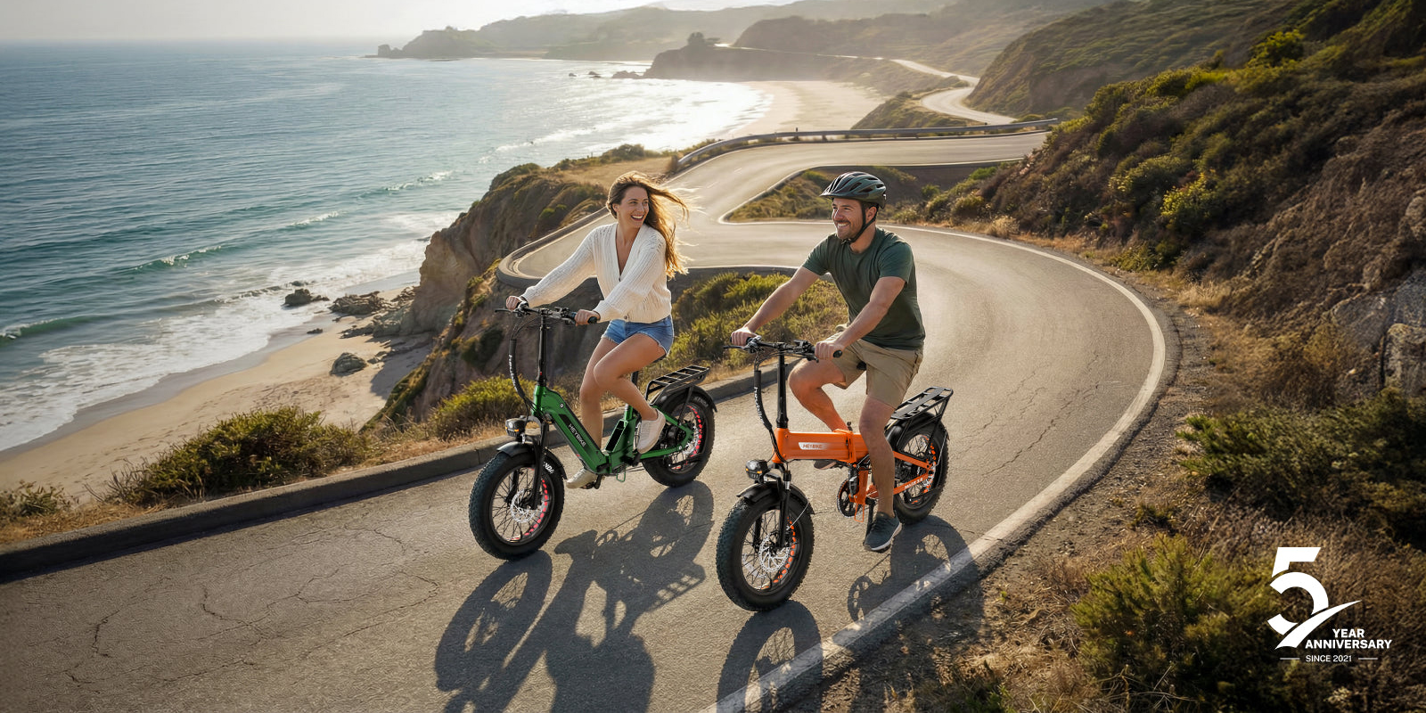 A man and woman riding bicycles on a road with a body of water
