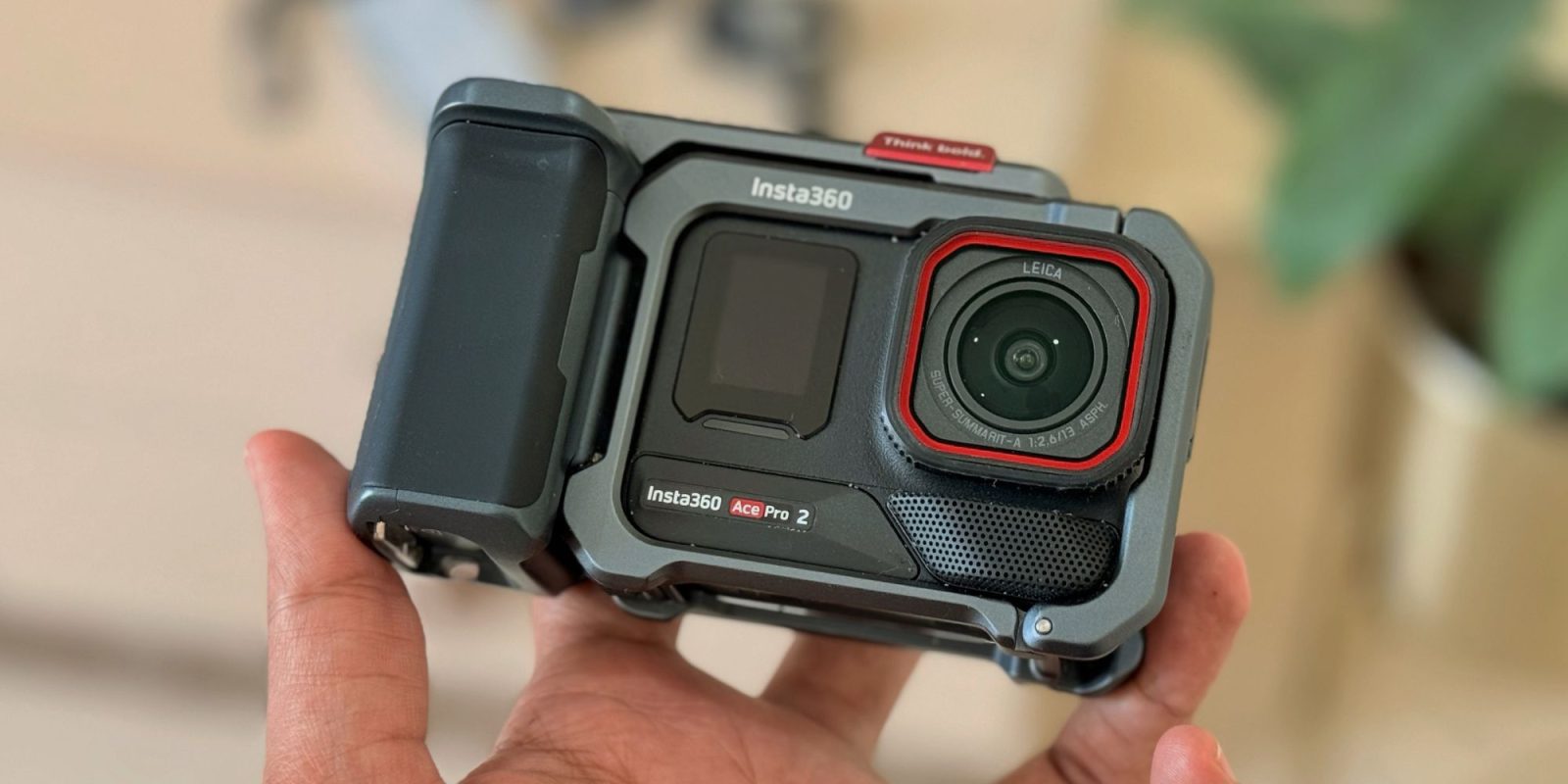 A hand holding a camera