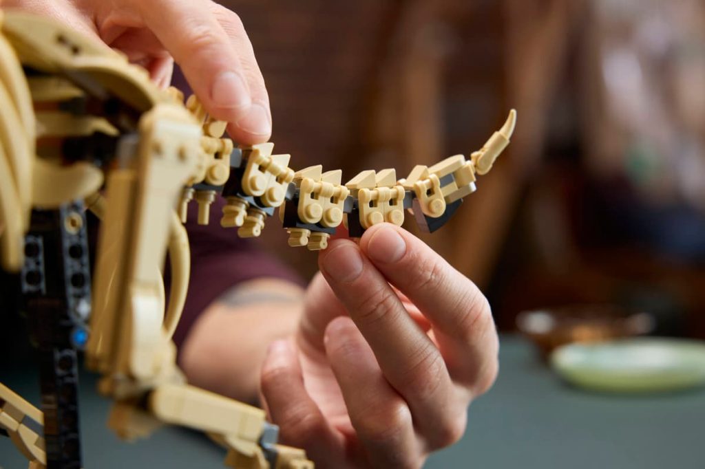 A person holding a model of a dinosaur