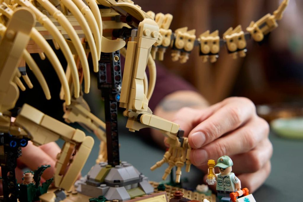 A person playing with a toy dinosaur