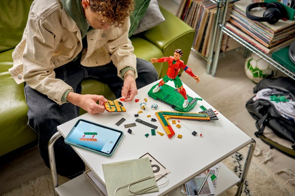 A man playing with toys on a table LEGO Editions