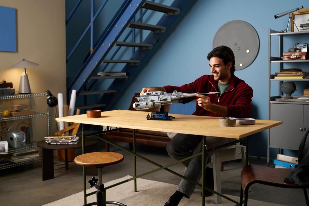 A man sitting at a table with a model of a spaceship