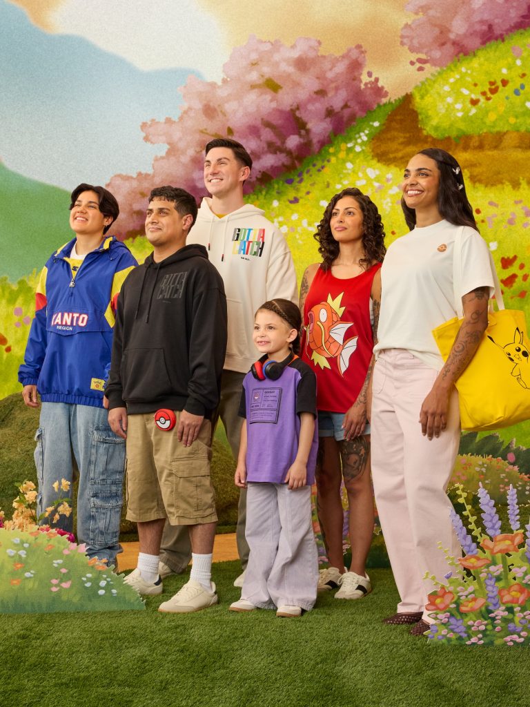 A group of people standing in front of a mural