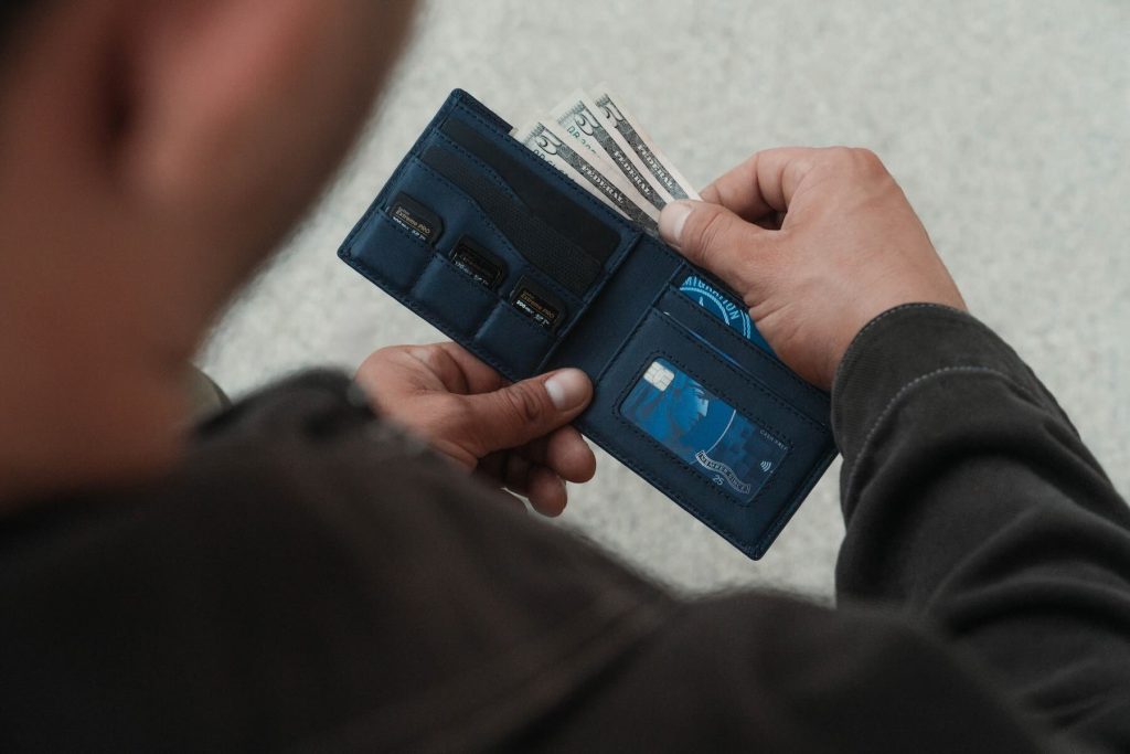 A person holding a wallet with money