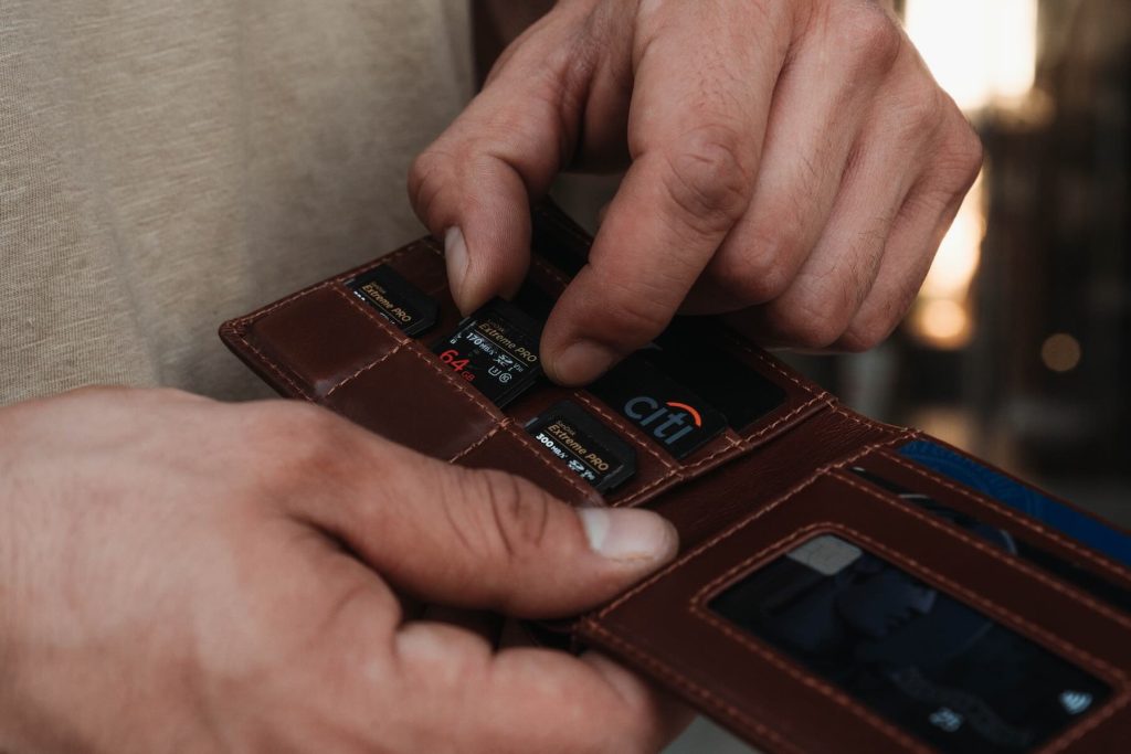 A person holding a wallet with a card in it