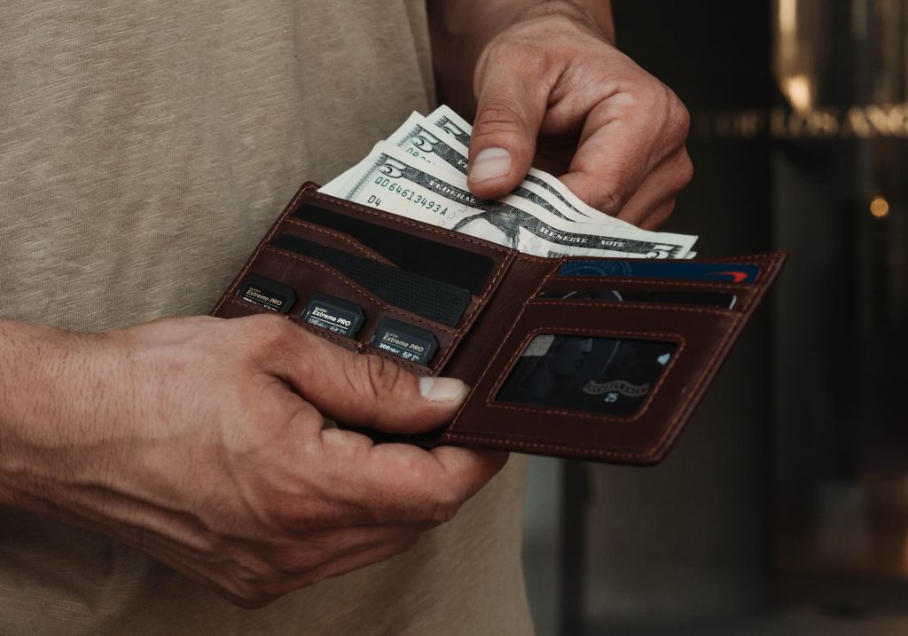 A person holding a wallet full of money