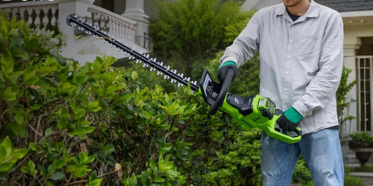 A person using a hedge trimmer