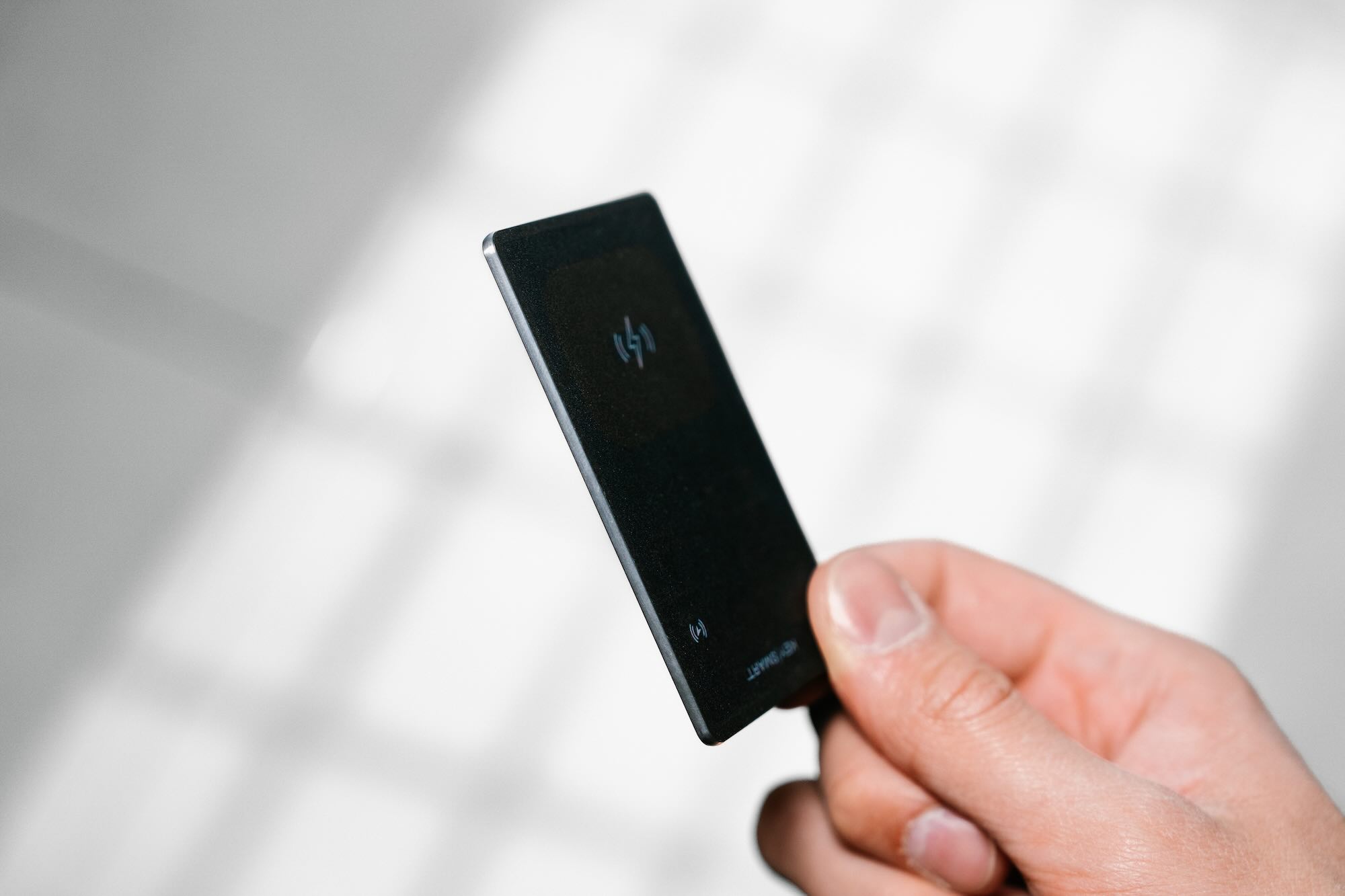 A hand holding a small black device