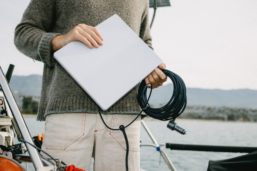 A person holding a laptop and a wire