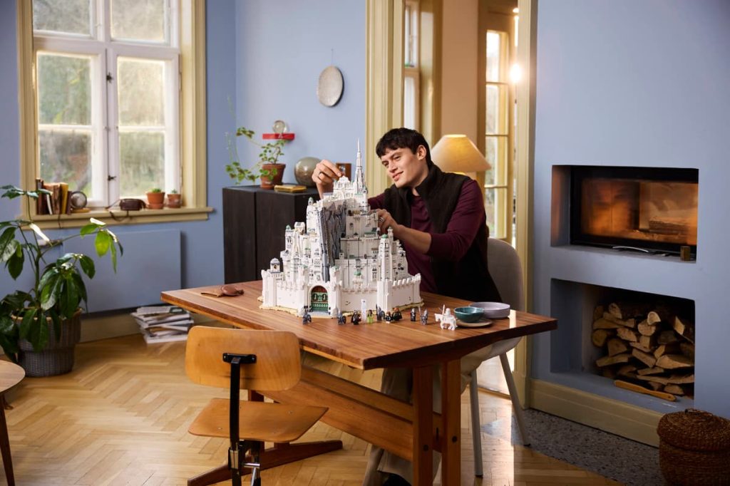 A man sitting at a table with a model castle