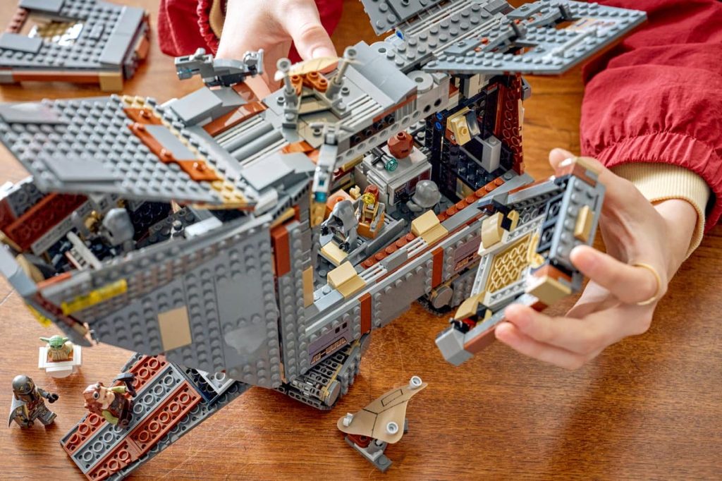 A person's hands playing with a building block
