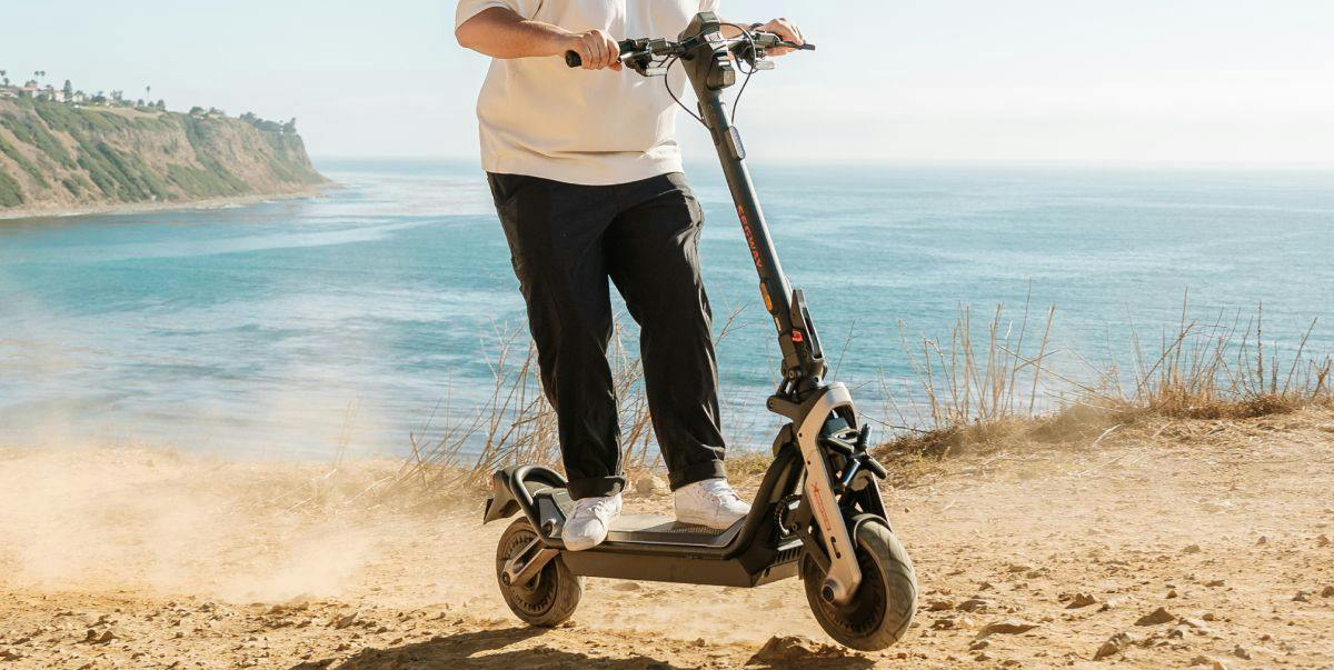 A person riding a scooter on a sandy beach