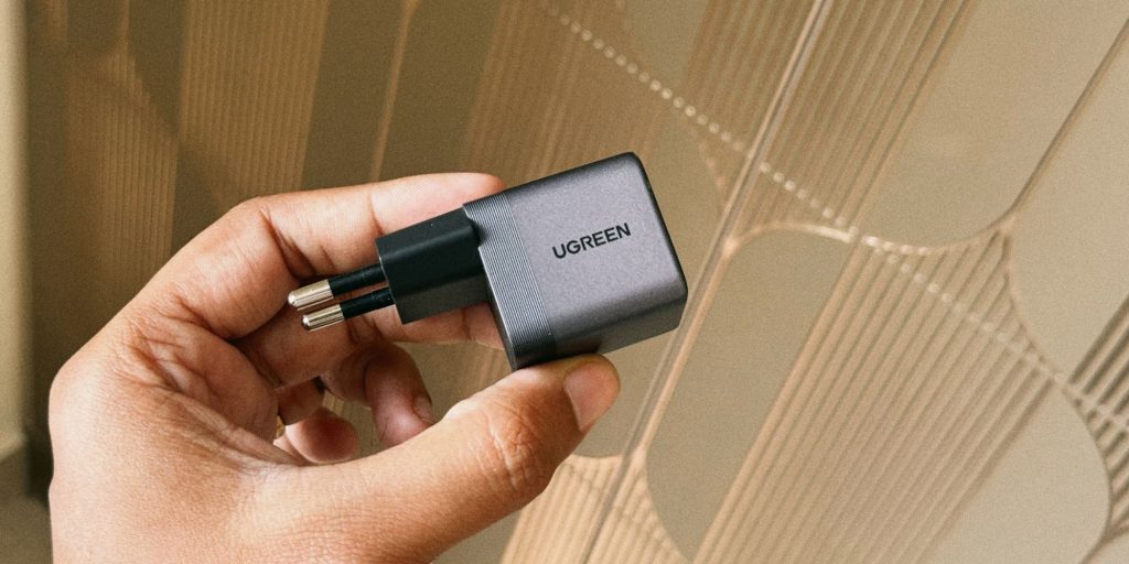 A hand holding a black charger