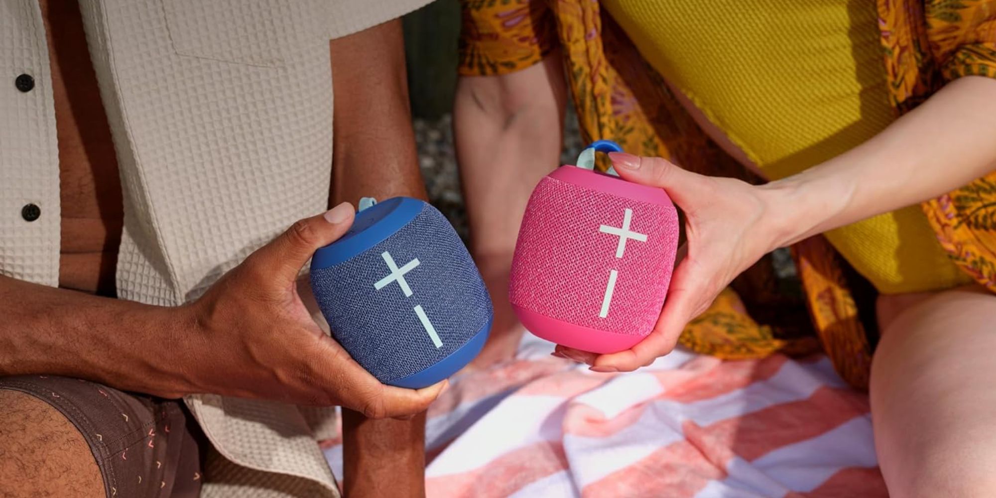 A group of people holding blue and pink speakers