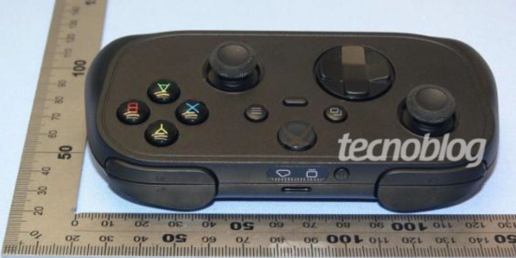 A black gaming controller with a ruler