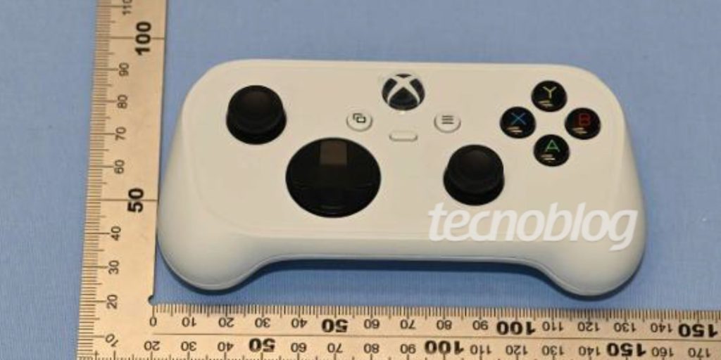 A white game controller with black buttons and a measuring tape