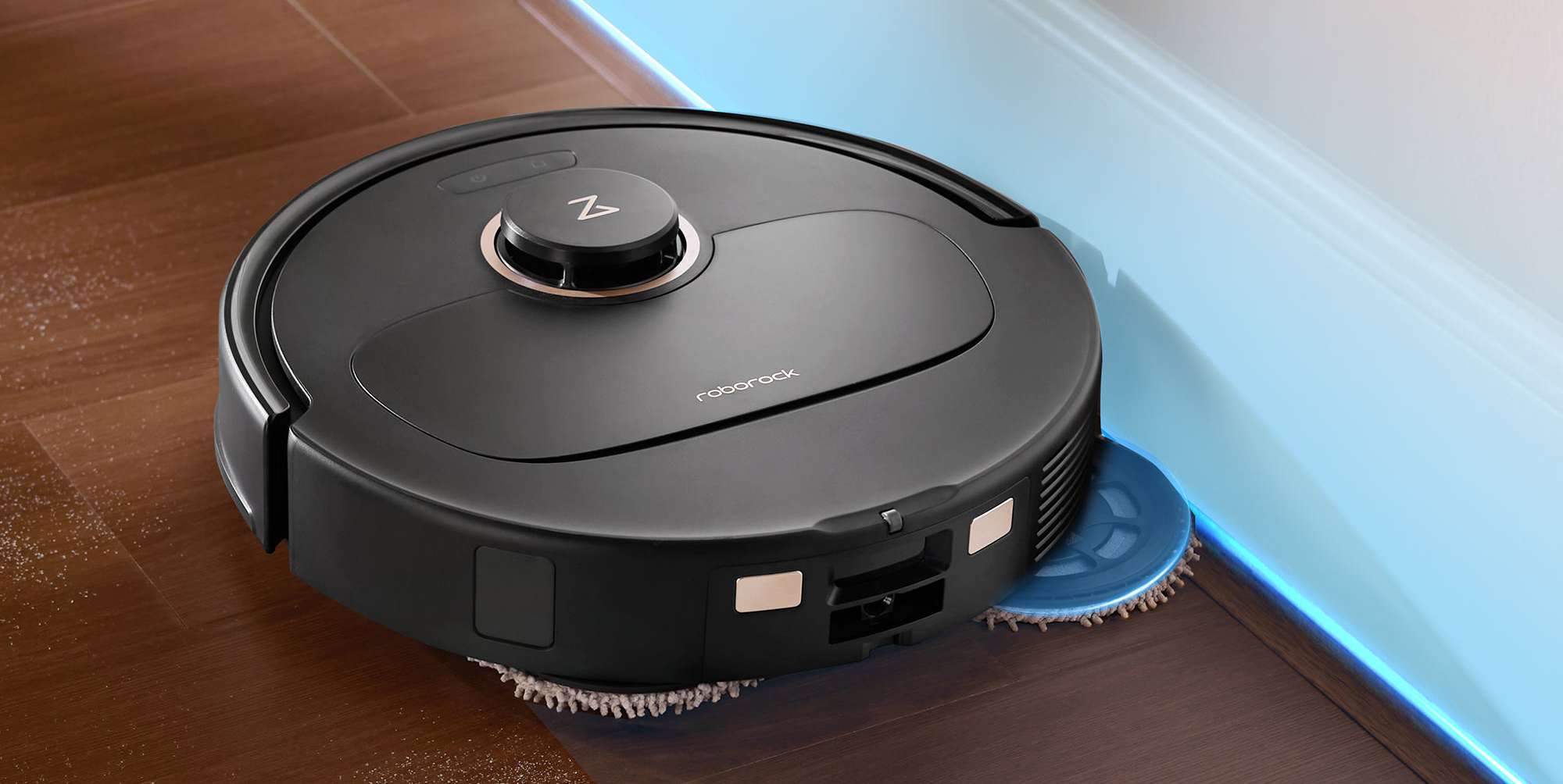 A black robot vacuum cleaner on a wood floor