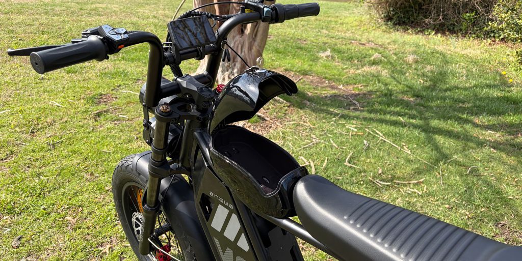 A black electric bike with a black helmet on the handlebars